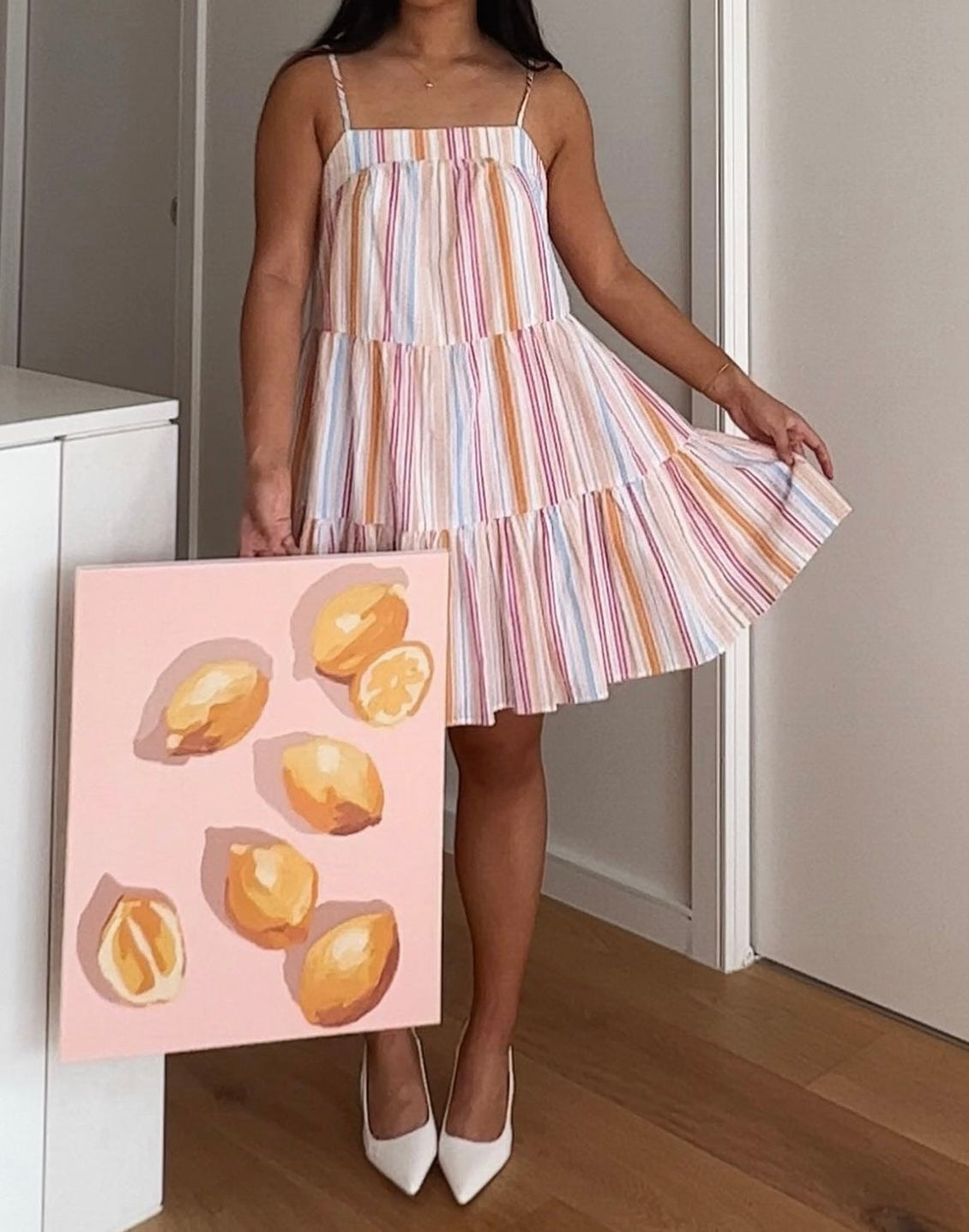 A girl holding the finished Pastel Lemons Big Framed Canvas Painting