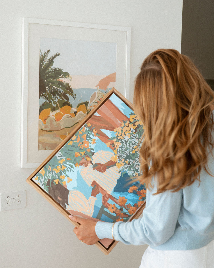 Paint Like Frida Sun & Lemons Big Rolled Canvas in white frame hanging on the wall and Tea in the Afternoon Big Framed Canvas