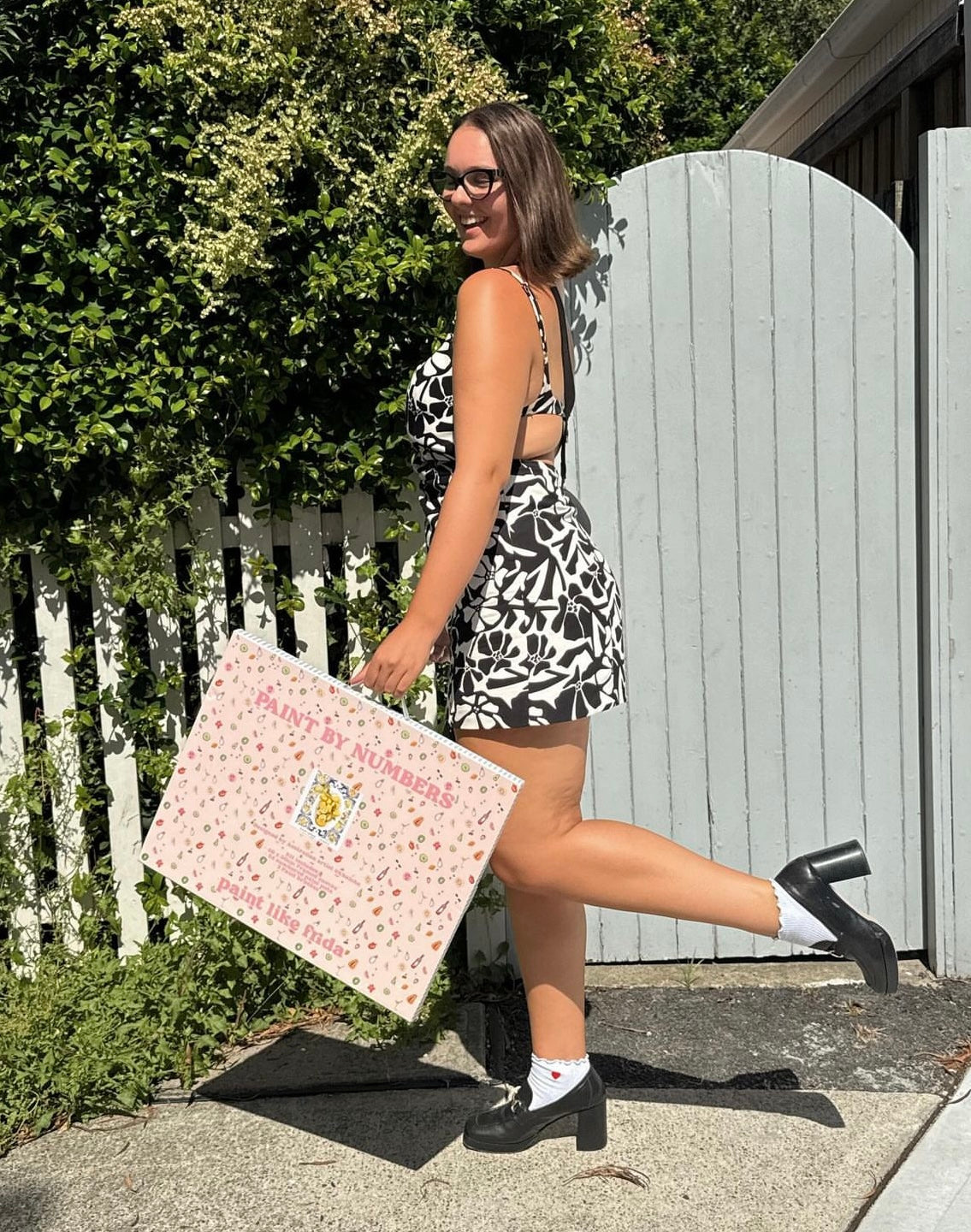 A girl holding a big framed Amalfi Lemons kit