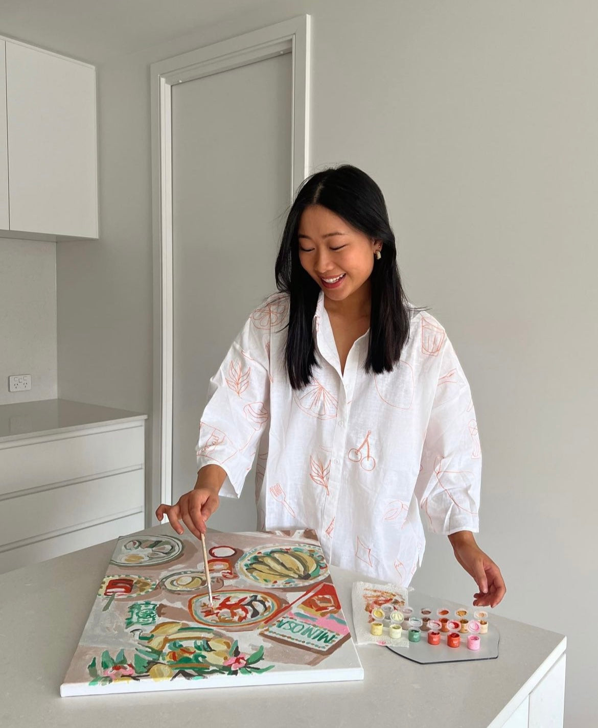A girl painting the Paint Like Frida The One with the Prawns big framed kit